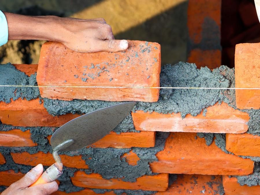Maçon posant des briques au mortier